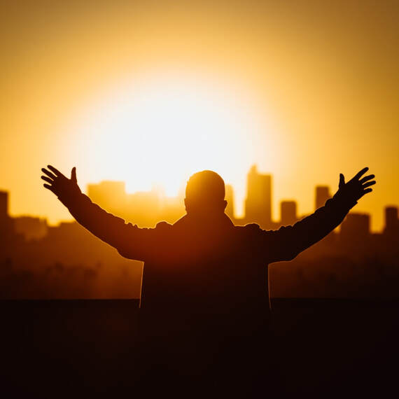 man facing sunrise